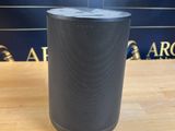 une enceinte noire posée sur une table en bois