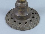 a small metal bell on top of a metal plate