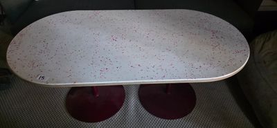 a white table with red legs and a white table top