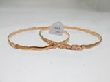 deux bracelets en or présentant des motifs gravés sur un fond blanc