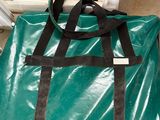 a large green bag sitting on the floor next to a window