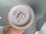 a person holding a cup with a sticker on it