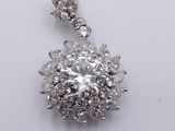an image of a diamond pendant on a chain on a white surface