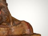 statue of a lion on a wooden base with a white background
