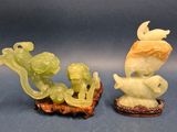 pair of carved jade figurines of a boy and a girl on a boat