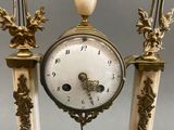 a clock that is sitting on top of a marble stand