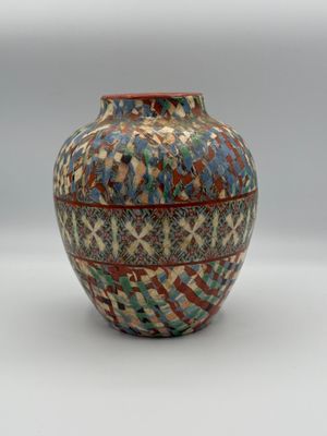 a vase that is sitting on a white surface