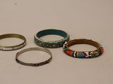 Trois bracelets différents sont posés sur une table avec un fond blanc.