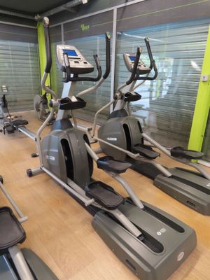 a row of stationary exercise bikes in a gym