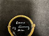 a close up of a black and gold ring with writing on it