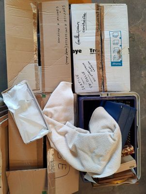 une boîte remplie de boîtes et de papiers posée par terre