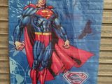 a close up of a superman poster hanging on a wall