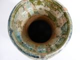 a close up of a vase on a white surface
