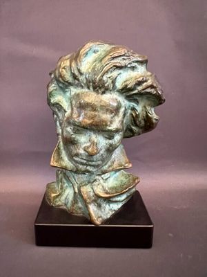 a statue of a man ' s head on a wooden base