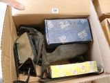 une boîte en carton remplie d'objets divers et une paire de ciseaux