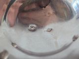 a person holding a silver plate with a hole in it