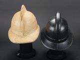 two helmets are sitting next to each other on a black surface
