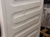 a white washing machine sitting on a pallet next to other appliances