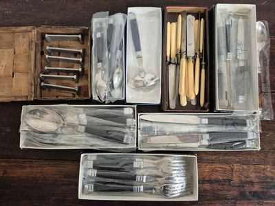 many different types of knives and spoons in a box