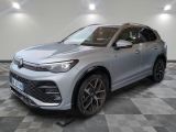 un SUV argenté garé sur un sol en damier dans un garage