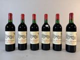 six bouteilles de vin sont alignées sur une table