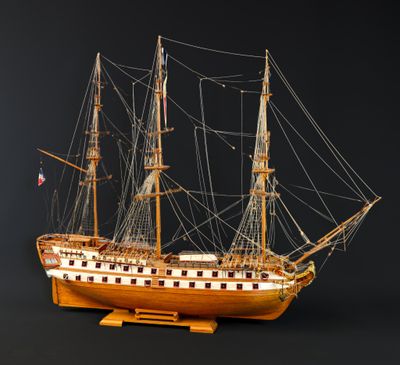 une vieille maquette en bois représentant un voilier sur fond noir