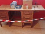 un bureau sur lequel se trouve une boîte, avec un mur rouge en arrière-plan