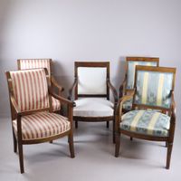 Cinq fauteuils en bois naturel ; garnitures de tissu.