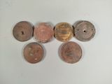 four different types of coins are arranged in a row on a white surface