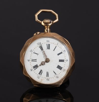 a gold pocket watch with roman numerals on the face