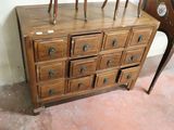 a wooden dresser with many drawers and a clock on top