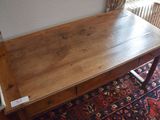 a wooden table with a drawer underneath it on a rug