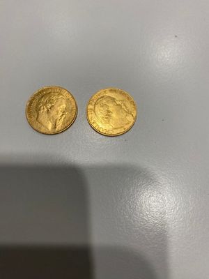 deux pièces d'or posées sur une table blanche