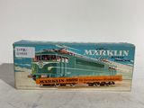 un vieux petit train en jouet est posé sur une surface blanche
