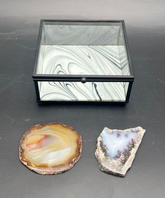 three pieces of agite are sitting on a table next to a glass box
