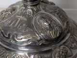 a silver plate with a candle on it sitting on a table
