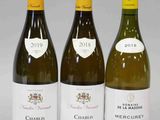 trois bouteilles de vin posées sur une table l'une à côté de l'autre