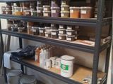 une étagère remplie de peinture et d'autres pots de peinture dans une pièce