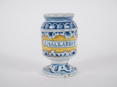 a small blue and white vase with a yellow label on it