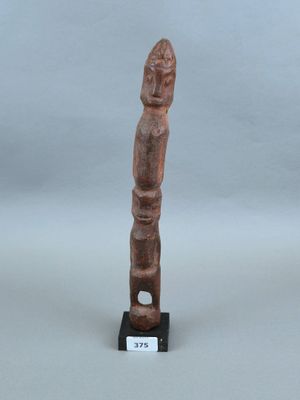 une petite statue en bois représentant un homme au long cou