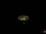 a green light in the middle of a black background