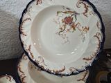 several plates and bowls are sitting on a table with a wall in the background