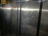 several stainless steel refrigerators are lined up in a room