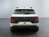 the rear of a white and black car in a white room