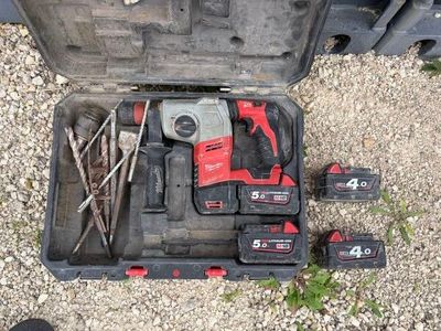 une boîte à outils contenant des outils, posée sur le sol