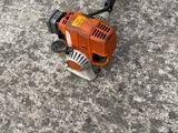 an image of a small lawn mower laying on the ground