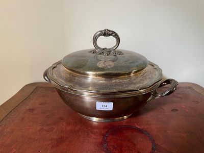 casserole plaquée argent avec couvercle en verre posée sur une table en bois