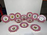 beaucoup d'assiettes roses et blanches sur une table