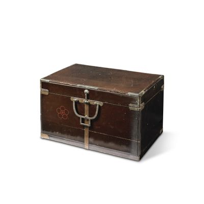 une petite boîte en bois munie d'une poignée métallique, posée sur une surface blanche
