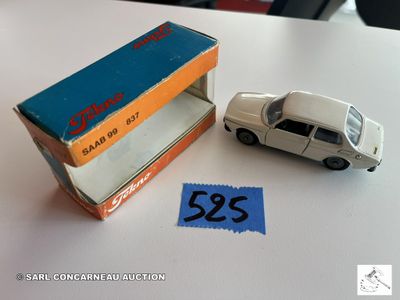 une petite voiture miniature posée sur une table à côté d'une boîte